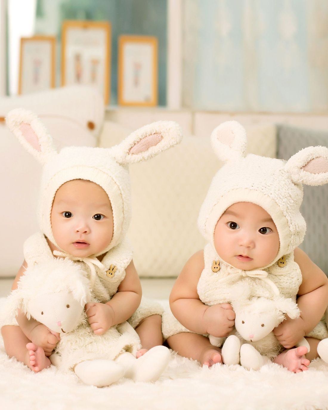 Two happy babies in knitted bunny hats