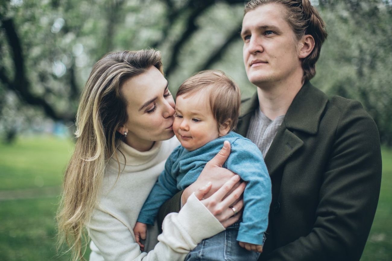 Young parents holding their baby outdoors